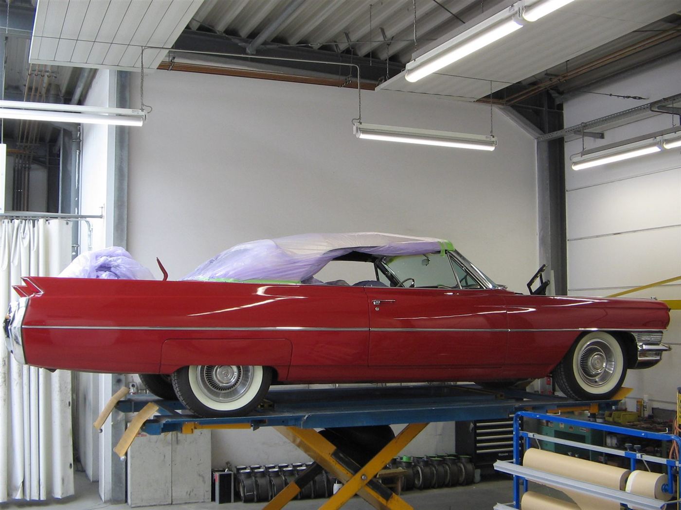 Roter Cadillac Cabrio auf der Hebebühne mit abgedecktem Verdeck
