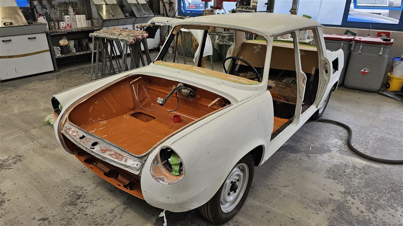 Oldtimer-Karosserie mit orange lackiertem Innenraum, Außenhaut weiß grundiert