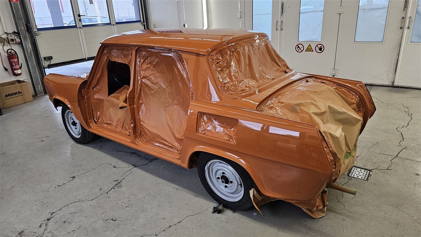 Orange lackierte Oldtimer-Karosserie, Fenster mit Papier abgedeckt