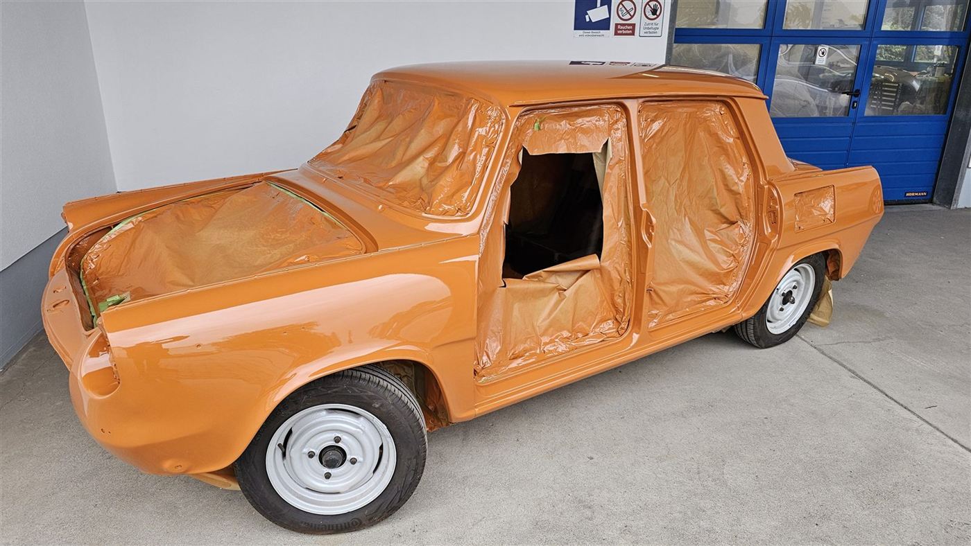 Orange Oldtimer-Limousine nach dem Lackieren in der Werkstatt