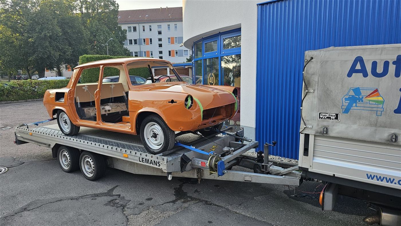 Oldtimer-Karosserie auf dem Autotransporter vor der Werkstatt