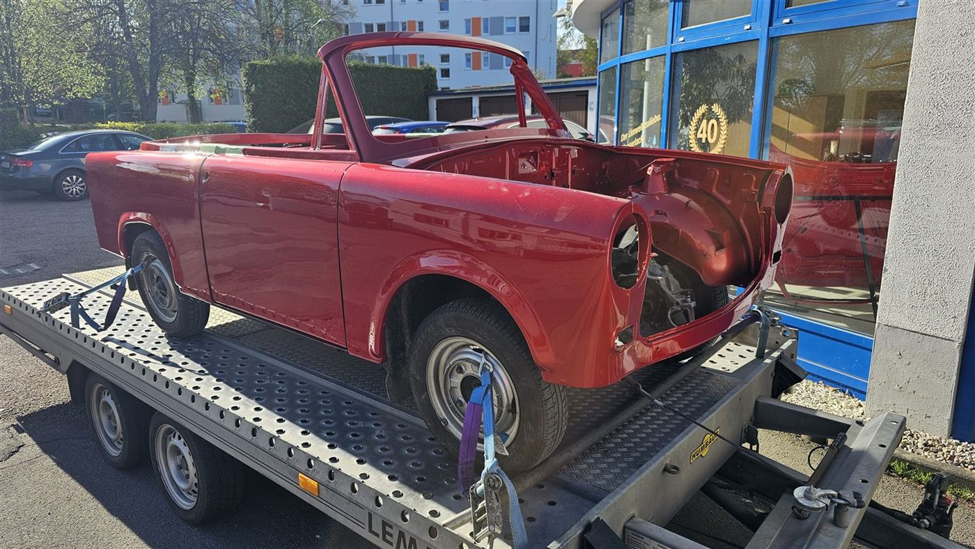 Rot lackierter Trabant auf dem Anhänger, bereit zum Transport