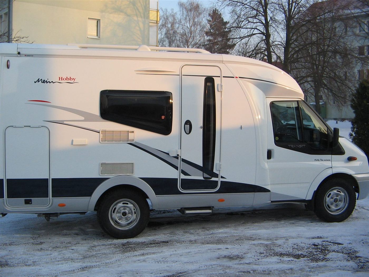 Fertig lackiertes Wohnmobil im Winter vor der Werkstatt